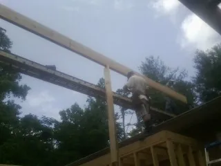 Carpenter setting a ridge beam over a new addition frame — Ice Dam Removal by Roofing Brothers in Mexico