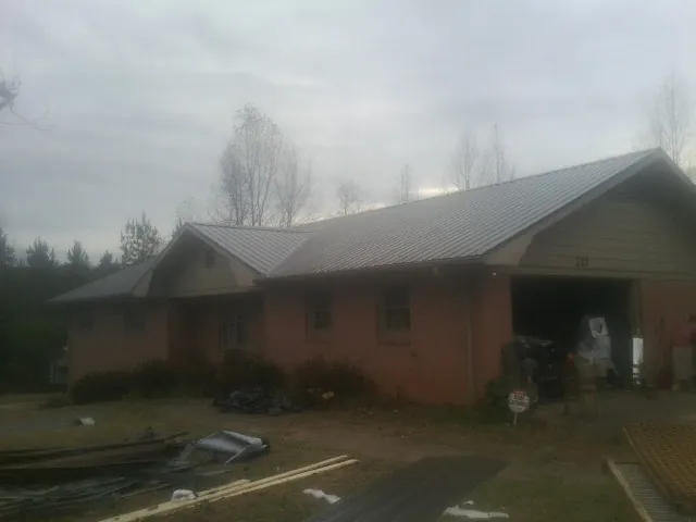 Gray metal roof on a stucco house with an attached garage in Mexico